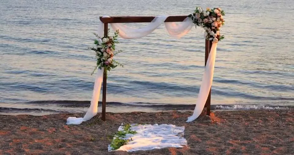 A wedding arch set on the beach at sunset