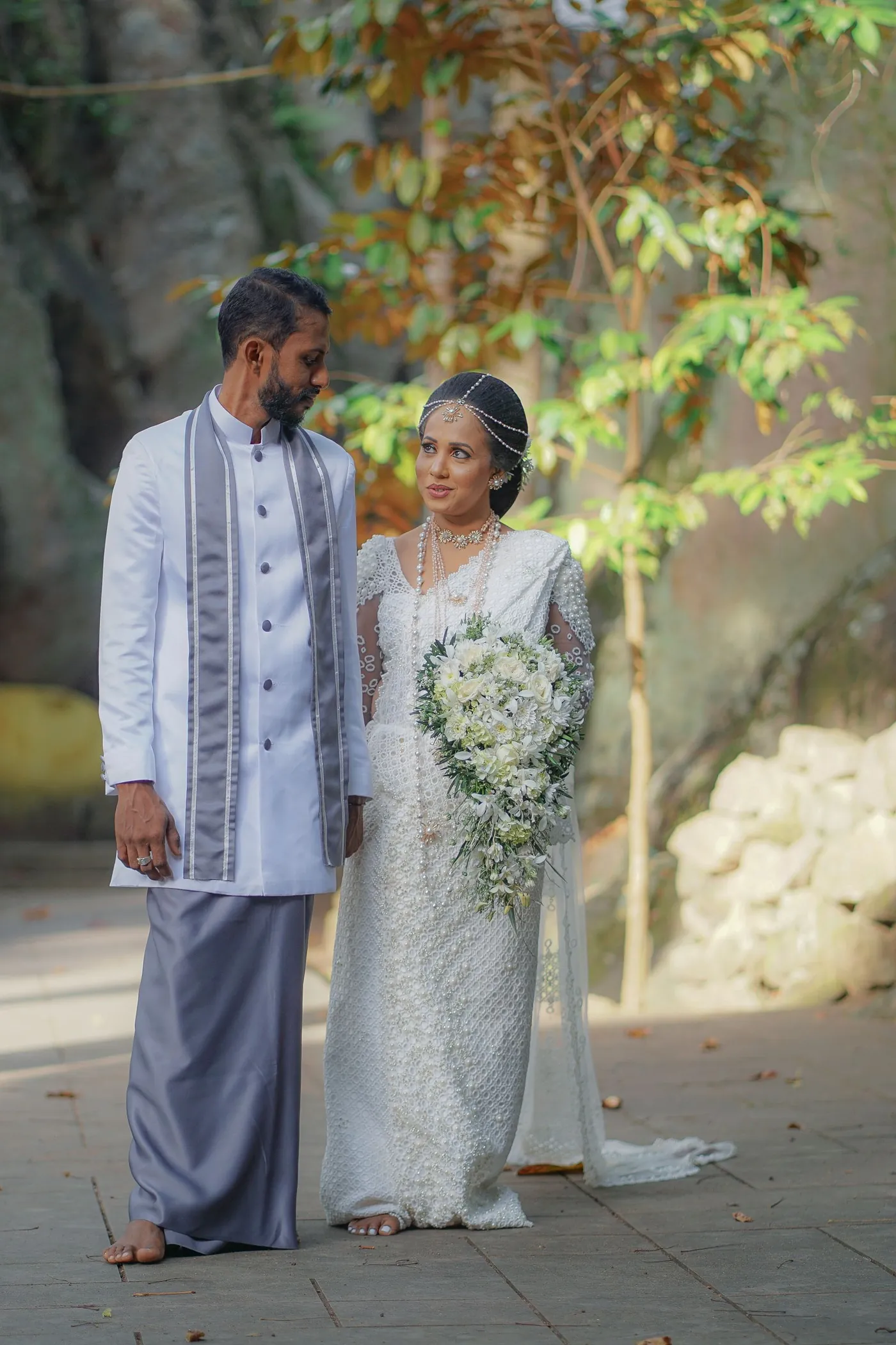 A newly married couple walking in a garden